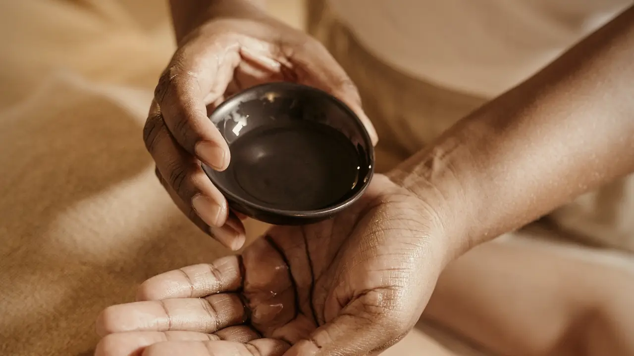 Warm massage oil poured for a home spa session in Dubai